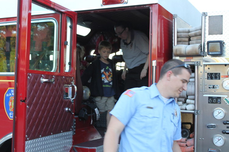 Children and firefighters gathered around a fire engine